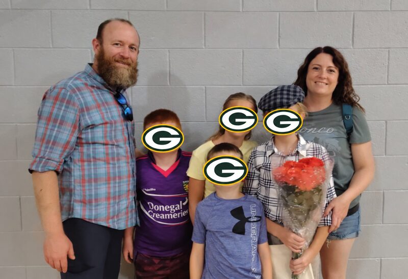 Josh with his family, with Packers logos covering the children's faces